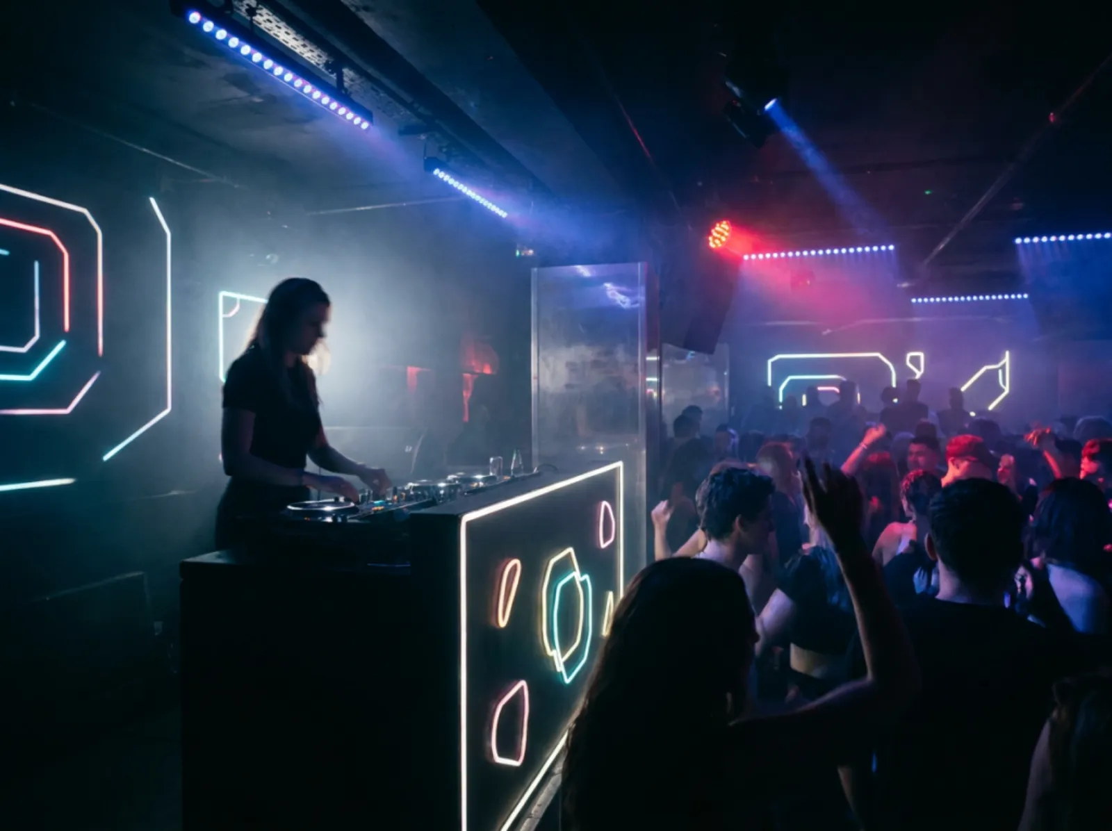 Female DJ under blue and red stage lighting